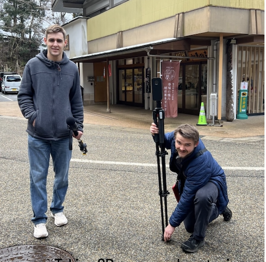 Dylan and Alec assembling the Matterport camera and holding a audio recorder attached to a monopod pole.